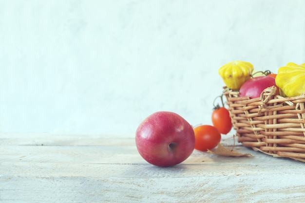 木製のテーブルの収穫の概念のバスケットに新鮮な熟した野菜や果物
