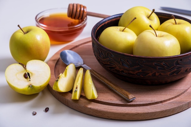 Свежие спелые целые и нарезанные желтые яблоки с медом