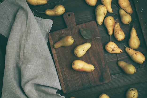 Fresh ripe yellow pears on a brown wooden table, top view