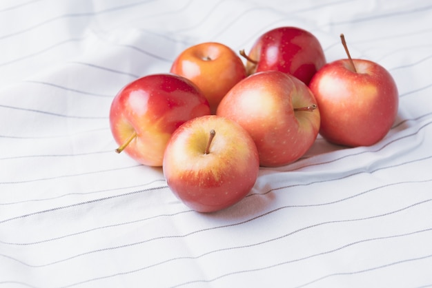 Photo fresh ripped red apples on table cloths.