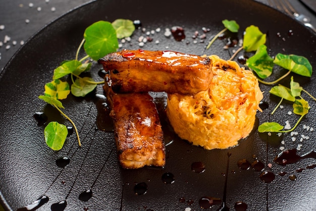 Fresh roasted fish sticks with cabbage on the black background