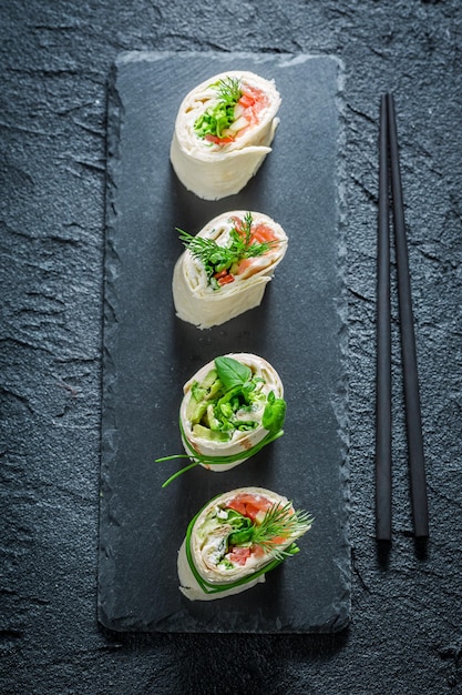 Photo fresh rolls with salmon cheese and vegetables for a snack