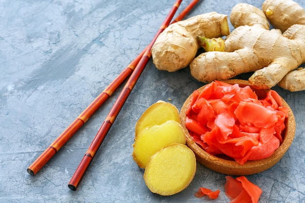 Fresh root slices of pickled ginger and chopsticks