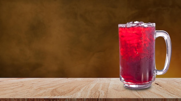 Fresh Roselle juice sweet water and iced in glass on wooden table with dark background Summer health drinks with ice Red juice with ice cubes in glass