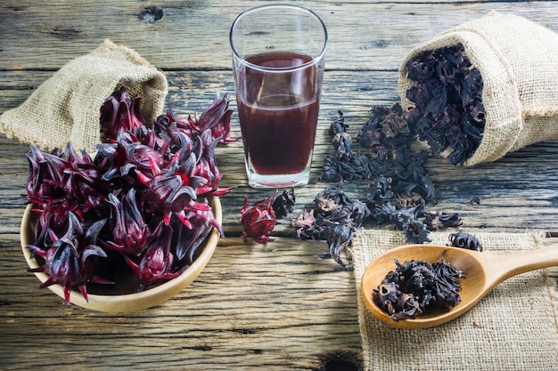 Fresh roselle, roselle dried and roselle juice on a wooden table. 