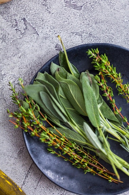 Fresh rosemary and sage spices on a black plate from the local organic garden.