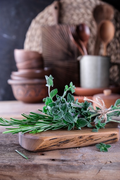 Photo fresh rosemary and thyme on a wooden cutting board. kitchen in retro style