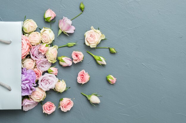 Fresh roses assortment. Copy space on grey background. Flat lay.