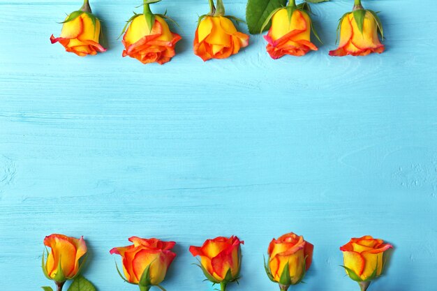 Fresh roses frame on wooden background