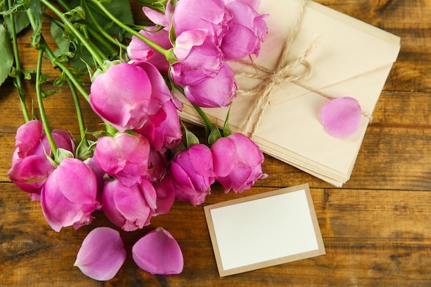 Fresh roses and present on wooden background