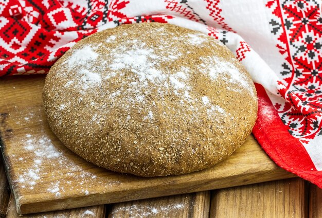 Fresh round homemade bread with colorful towel on the table