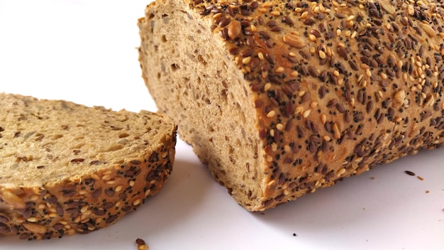 Photo fresh rye bread cut into pieces white background bread with bran and seeds