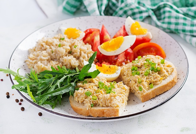 Fresh salad. Breakfast bowl with oatmeal, sandwiches with chicken rillettes, tomato and boiled egg. Healthy food.