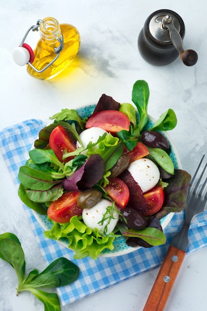 Fresh salad in a ceramic mug on a light background