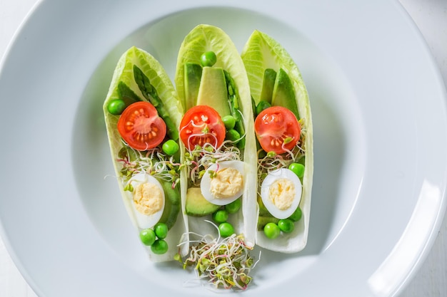 Fresh salad in chicory with avocado asparagus and peas