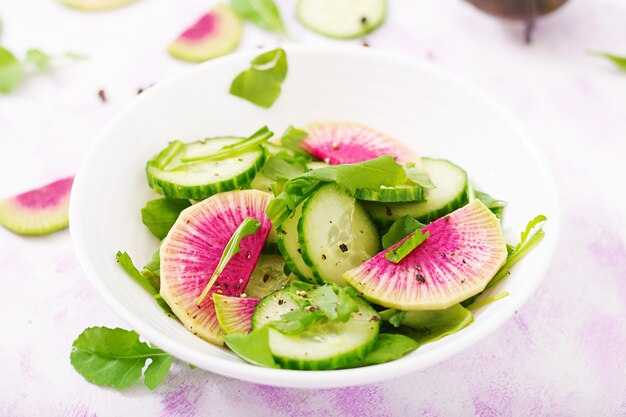 Fresh salad of cucumbers, watermelon radishes and arugula. 