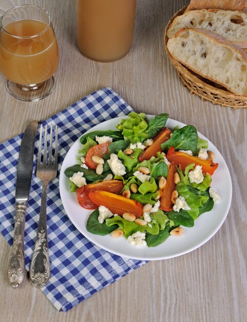 Fresh salad mix with persimmons, feta cheese and peanuts