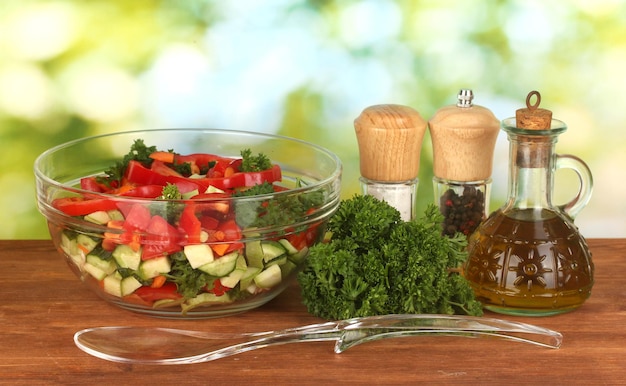 Fresh salad and oil on green background