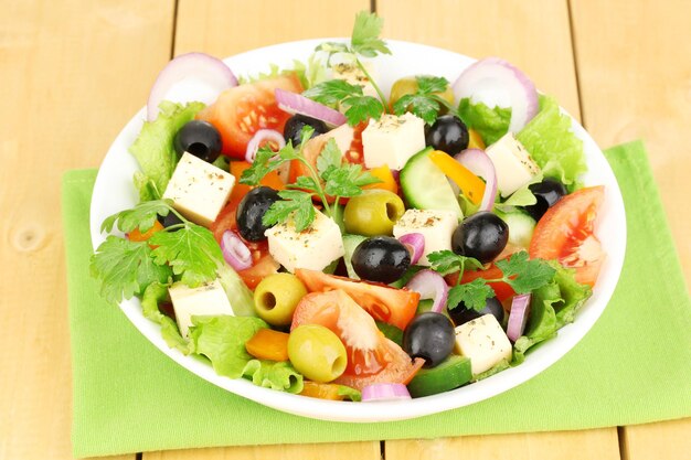 Fresh salad in plate on wooden table