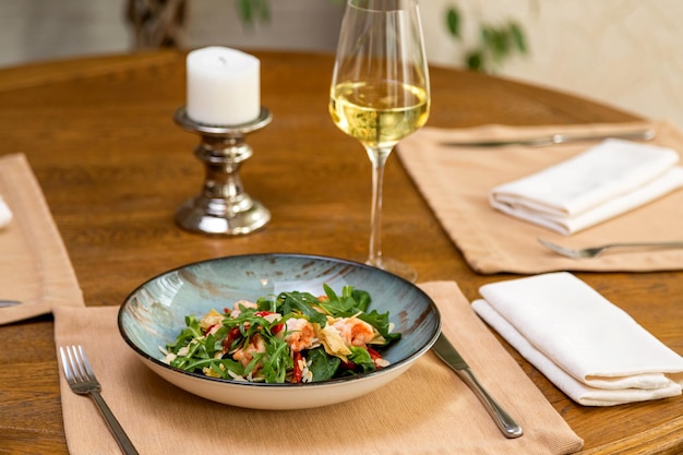 Fresh salad served with a glass of wine served table