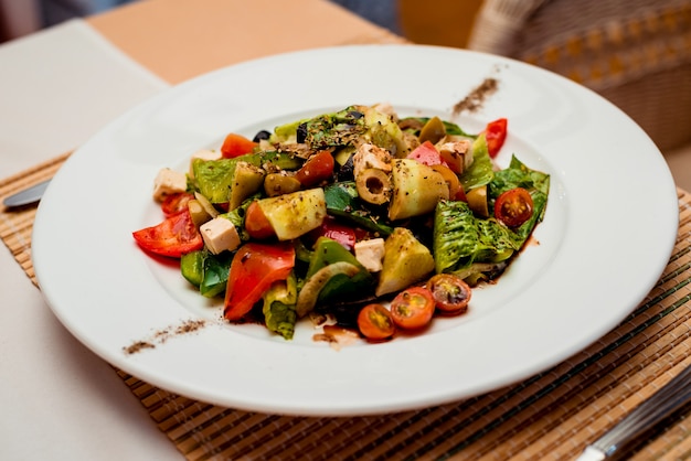 Fresh salad on the white plate. Restaurant.