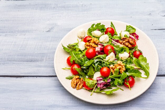 Fresh salad with arugula, radicchio, tomato cherry, baby mozzarella, walnuts