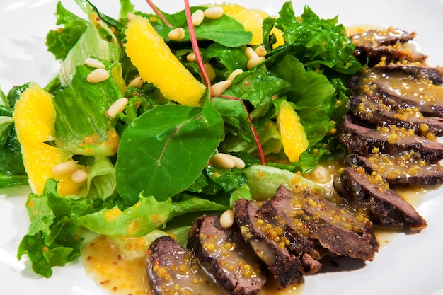 Fresh salad with chard leaves and lettuce with oranges and beef fillet