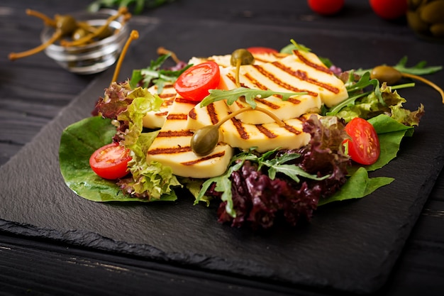 Fresh salad with grilled cheese, tomatoes, capers, lettuce and arugula.