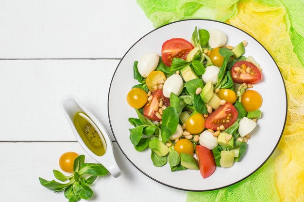 Fresh salad with mozzarella tomatoes avocado and lettuce