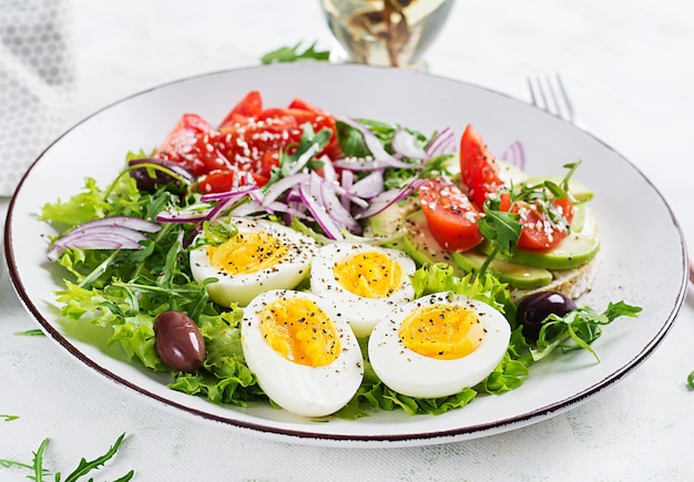 Insalata fresca con pomodoro olive uova sode e panino con ricotta avocado