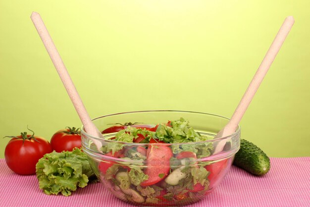 Fresh salad with tomatoes and cucumbers on green background