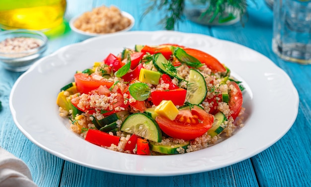 Photo fresh salad with vegetables quinoa and fresh herbs on a blue background tabbouleh salad side view closeup