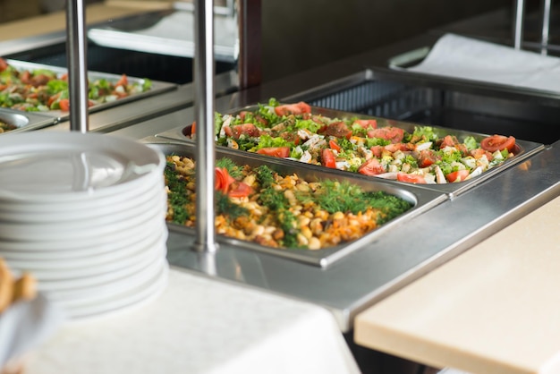 Fresh salads in boilers on the buffet table