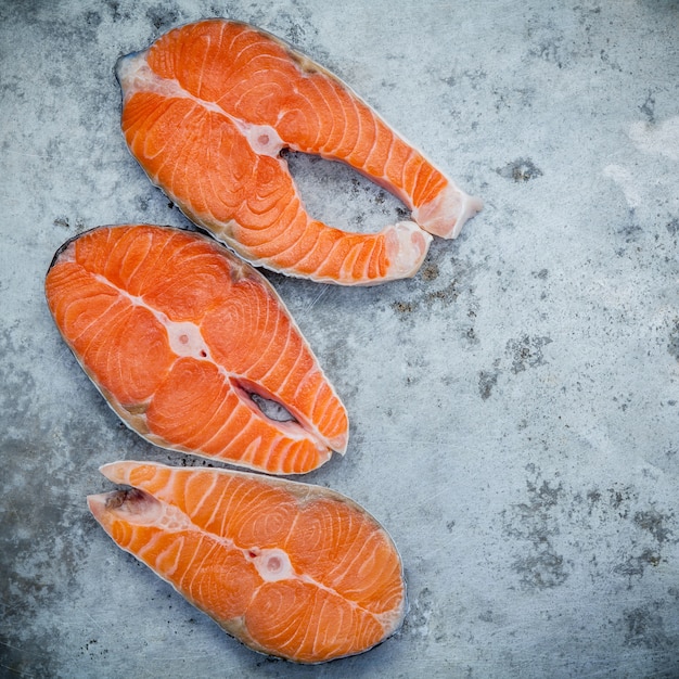 Fresh salmon fillet sliced flat lay on shabby metal background.