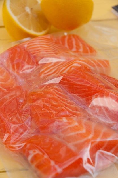 Fresh salmon fillet in a vacuum package with lemon