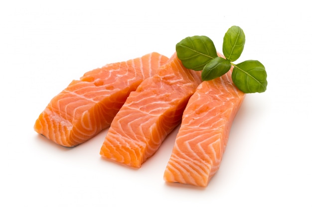 Fresh salmon fillet with basil on the white background.