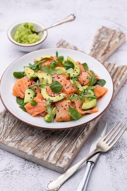 Fresh salmon salad with avocado,  for keto and low carb diet. Rusty background, top view, copy space.