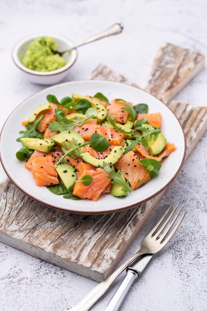 Fresh salmon salad with avocado,  for keto and low carb diet. Rusty background, top view, copy space.