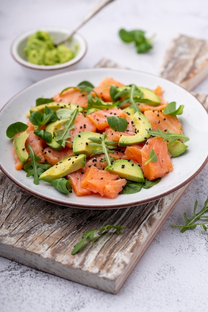 Fresh salmon salad with avocado,  for keto and low carb diet. Rusty background, top view, copy space.