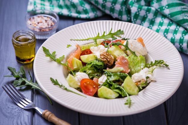 Fresh salmon salad with red tomatoes, soft cheese,cucumber,nuts and arugula