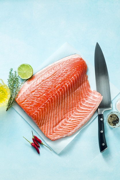 Fresh salmon slice on a wooden cutting board with a chef's knife on the table. cooking recipe. food background. fresh fish products