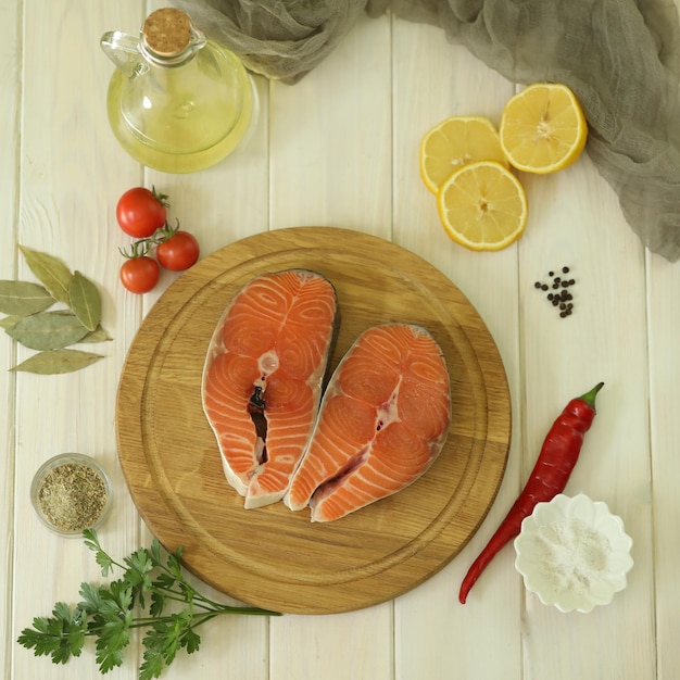 Fresh salmon steak with ingredients on  white wooden background