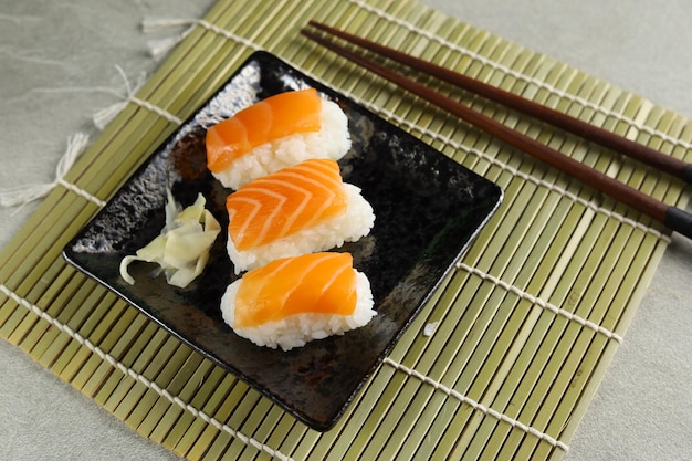 Nigiri di sushi di salmone fresco servito su piatto di ceramica