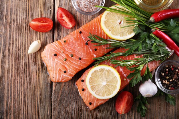 Fresh salmon with spices and lemon on wooden table