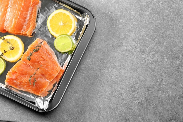 Fresh salmon with thyme and lemon on baking tray