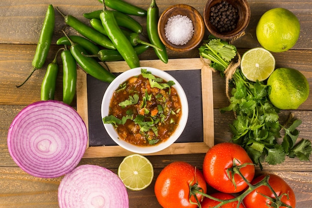 Fresh salsa in white bowl with ingredients.