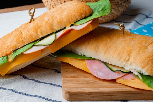 Fresh sandwich with sausage and lettuce on table