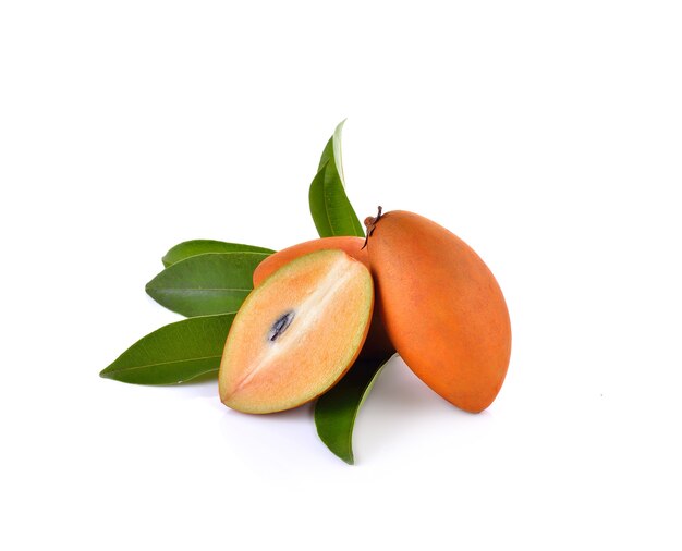 Fresh sapodilla with leaves on white wall