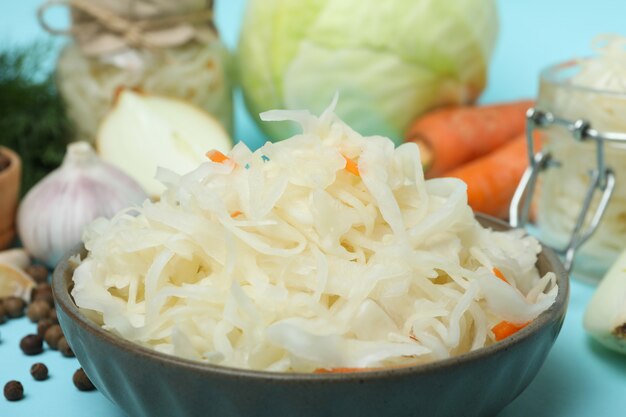 Fresh sauerkraut and ingredients on blue