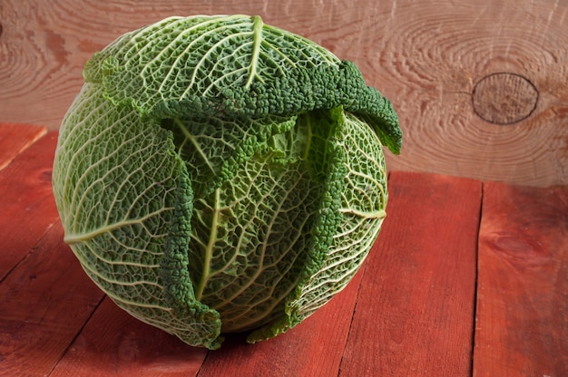 Fresh savoy cabbage closeup on rustic wooden background